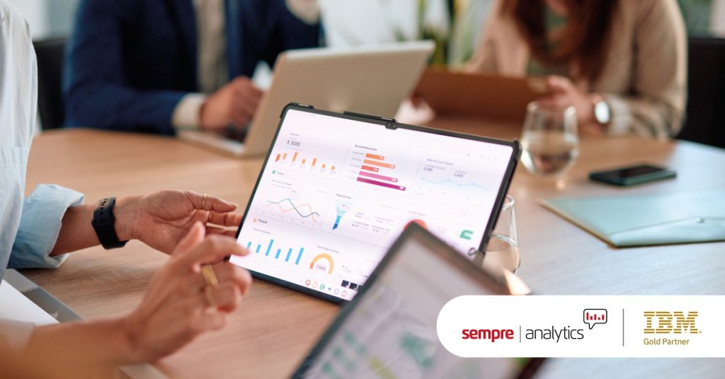 Main: A roundtable exploring a data analytics dashboard. Inset: Sempre Analytics and IBM Gold Partner logos.
