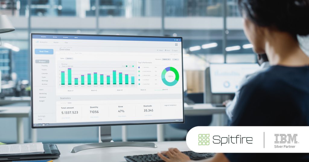 Main: A university employee looks at a planning analytics dashboard while working at her desk. Inset: Spitfire and IBM Silver Partner logos.