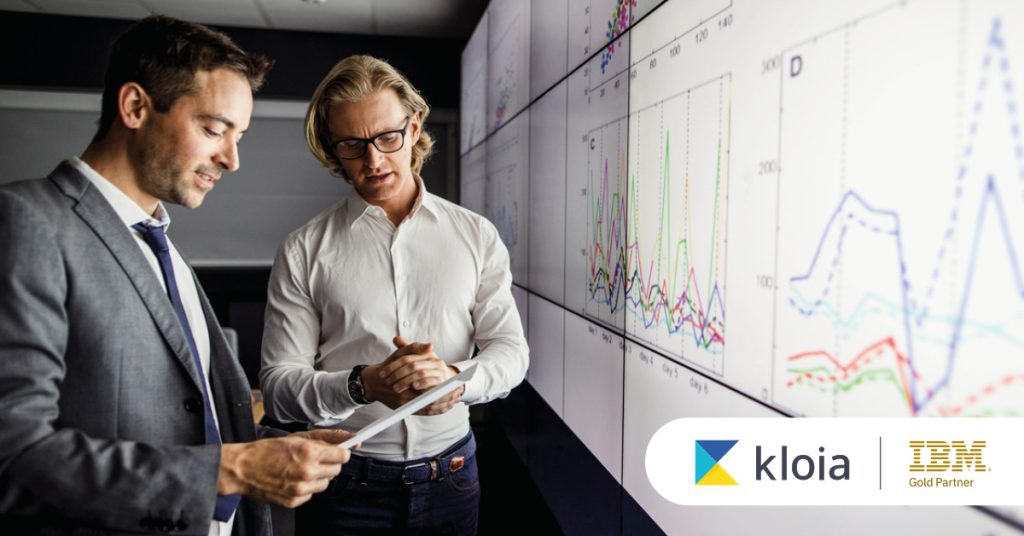 Main: Two employees analyse results from a digital dashboard. Inset: Kloia and IBM Gold Partner logos.