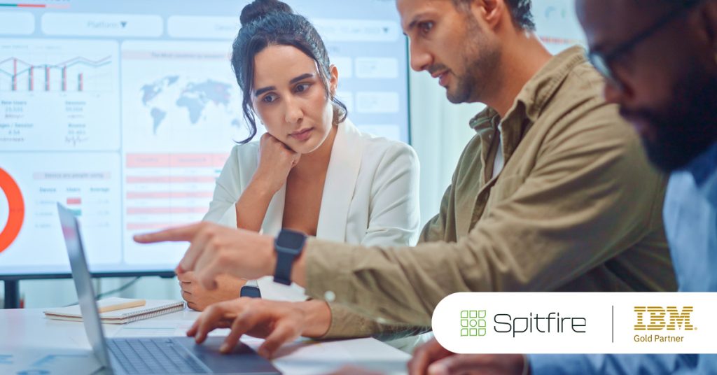 Main: A team of workers analyses a global planning analytics dashboard. Inset: Spitfire Analytics and IBM Gold Partner logos.